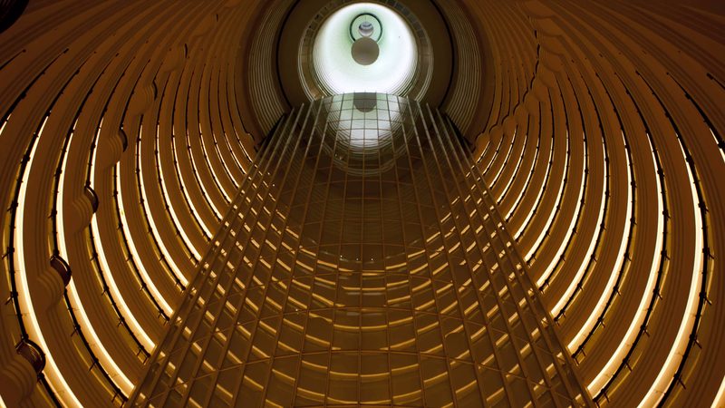Looking up a golden spiral hotel atrium in Shanghai
